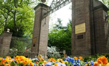 brick entrance with sign surrounded by flowers