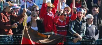 fans in red cheering at an outdoor event