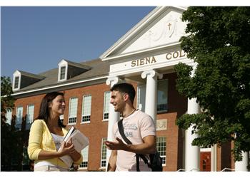 students chatting in front of 'sienna college' building