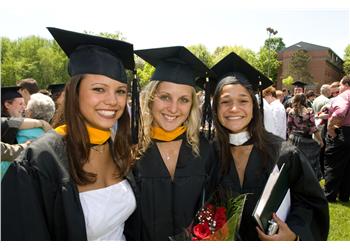 graduates smiling with 'sienna college' sash