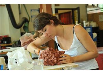 a woman molding clay in an art workshop