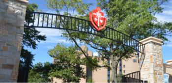 arched gate with a crest at a college entrance