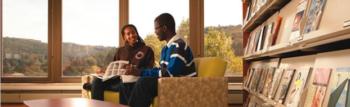 students conversing in a library with a scenic view