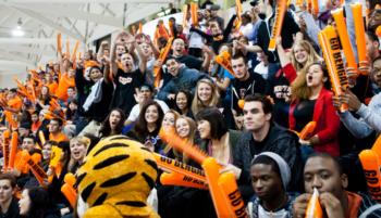 crowd cheering with orange props and mascot