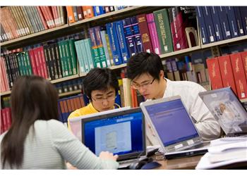 students studying with books and laptops