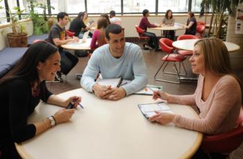 three people having a discussion at a round table