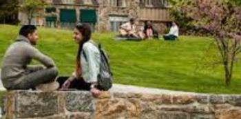 two students sitting and talking on campus