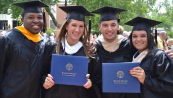 graduates holding diplomas smiling