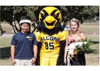 two people and mascot outdoors