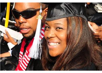 two graduates smiling with tassels and sunglasses