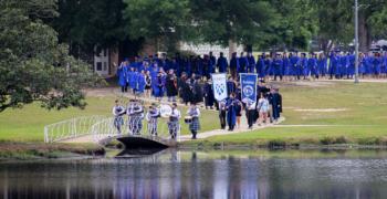 graduates walking over bridge in procession