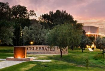 campus building at dusk with 'celebrated' monument