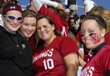 students cheering at a sports game in red jerseys with 'vikings 10'