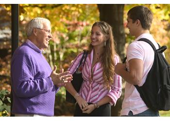 three people talking on campus