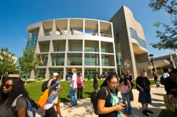 students outside modern building with 'csu' emblem