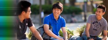 three students talking on campus benches