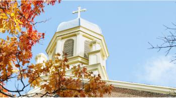 church dome with cross against autumn foliage