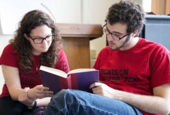 two students reading book wearing 'denison' shirts