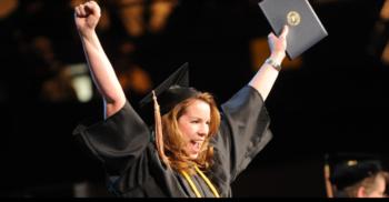 graduate with raised arms at commencement