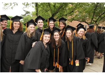 group of graduates smiling in caps and gowns