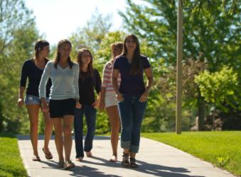 students walking on a sunny campus pathway