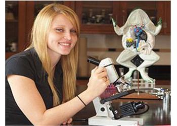 student with microscope and a model