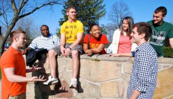 group of students sitting outside on campus