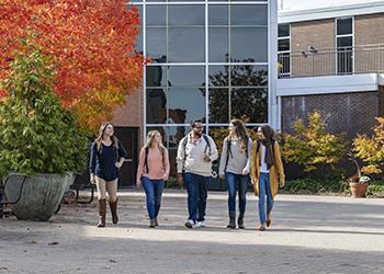 students walking and chatting on a campus pathway