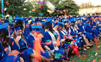 graduates throwing caps in air with confetti