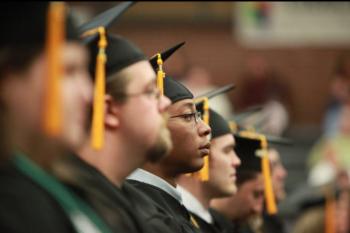 close-up of graduates in caps and gowns seated in a row