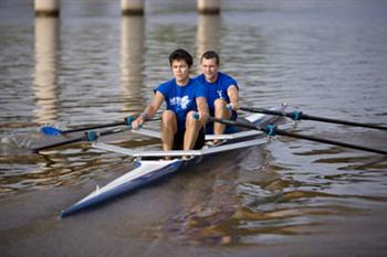 two people rowing a boat on calm waters