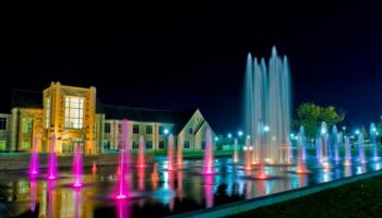 illuminated fountains at night, nearby buildings