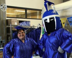 person in cap and gown with mascot