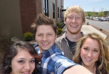 four smiling students taking a selfie