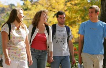 four students walking and talking on campus