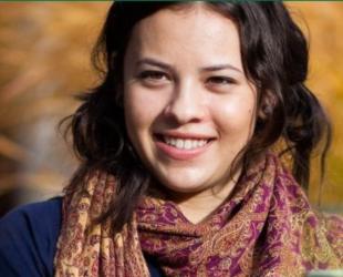 student smiling outdoors, autumn leaves