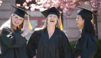 three graduates laughing and celebrating outdoors