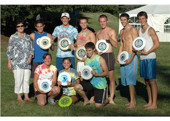 group holding frisbees outdoors