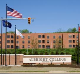 entrance sign of 'Albright College' with flags