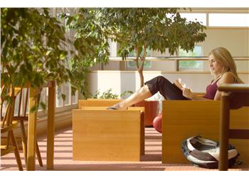 student reading book in campus lounge