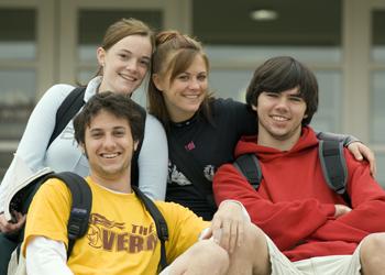 four students smiling and posing together