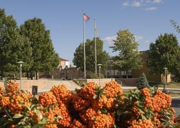 campus view with flag, trees and orange berries