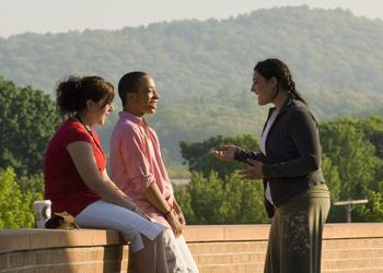 conversation on campus between three individuals