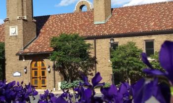 campus building with purple flowers in the foreground