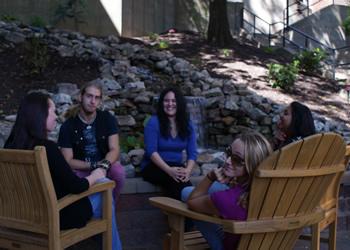 students chatting on wooden benches