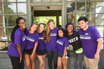 students smiling in front of a building