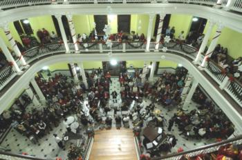 interior view of a caroling event in a decorated hall