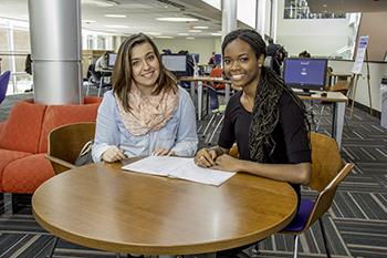 two students studying at a round table