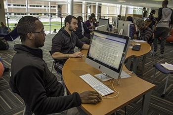 students studying in a library with computers