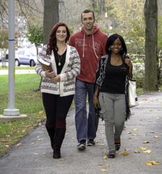 three students walking on a campus pathway